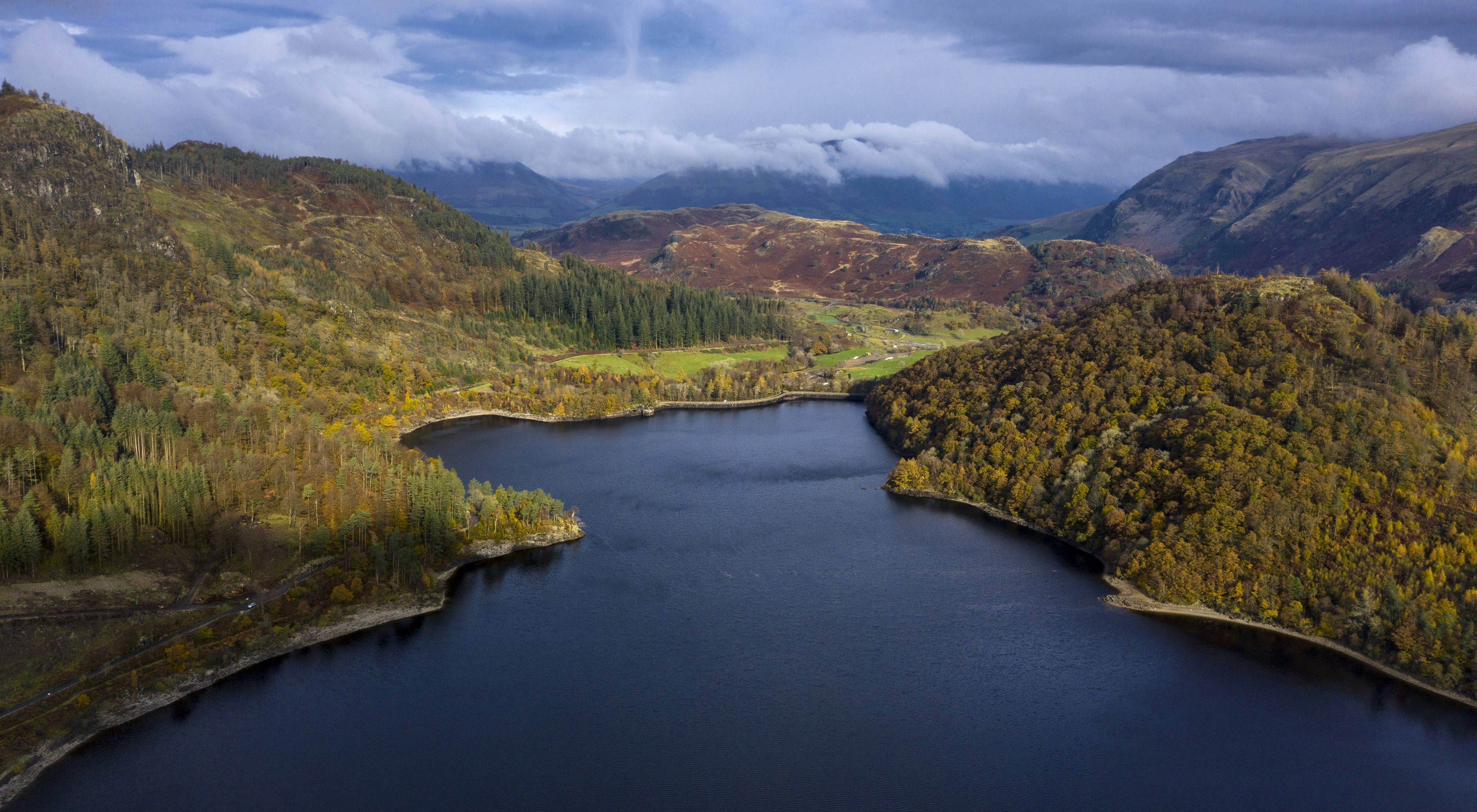 an aerial shot of a lake and mountains in England