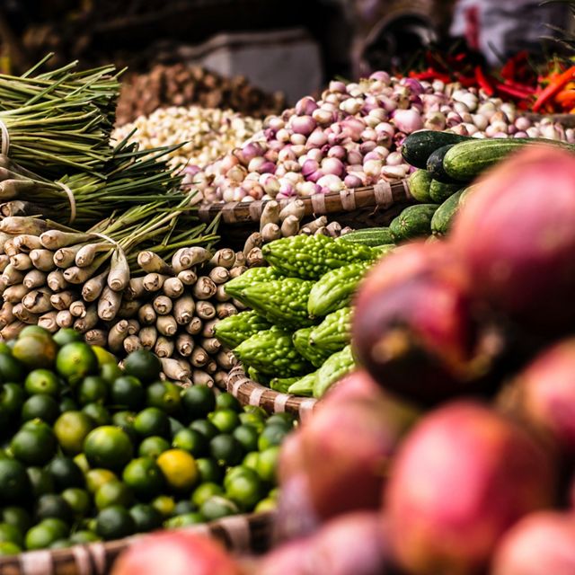 Large piles of vegetables on display at a fresh market.