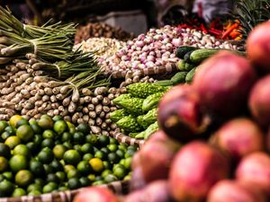 Large piles of vegetables on display at a fresh market.