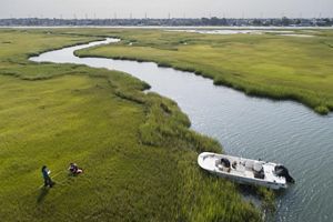 Aerial view of a marsh with scientists working on it. 