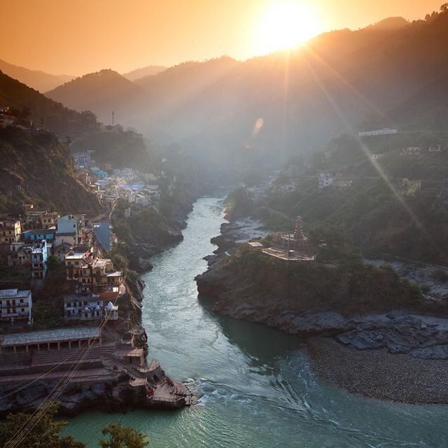 View from a high vantage point looking at a river that stretches between mountains and hillsides filled with buildings.