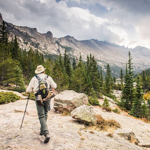 A park visitor hiking up to Mills Lake in Rocky Mountain National Park.