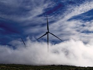 Photo of two wind turbines emerging from fog on the Paul da Serra plateau, Madeira, Portugal.