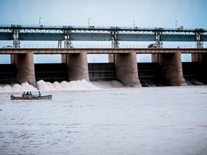 photo of a small boat near a hydropower dam in a river